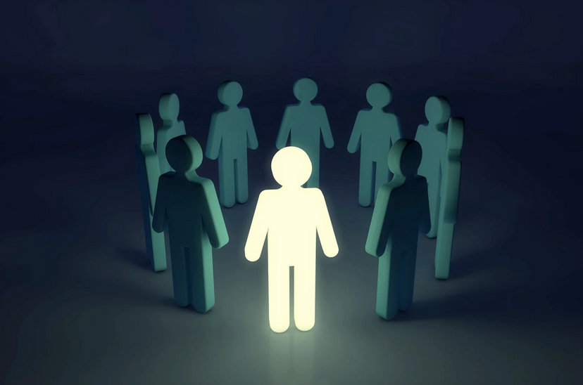 A glowing human figure stands in the center of a circle of dimly lit figures, symbolising leadership and influence.